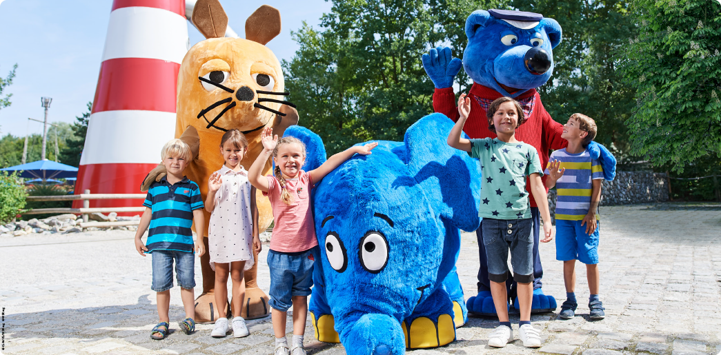 Winterkinder_Bild_Maskottchen mit Kindern vor dem Leuchtturm