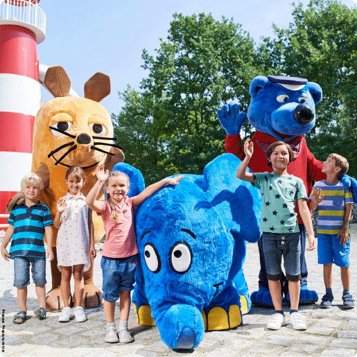 Winterkinder_Bild_Maskottchen mit Kindern vor dem Leuchtturm